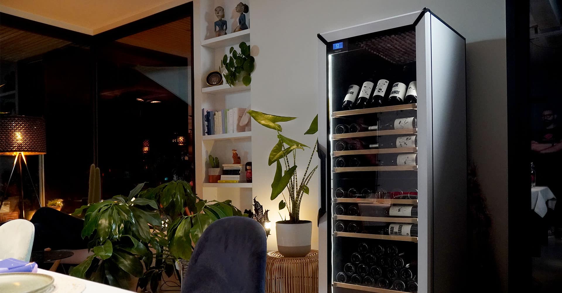Des bouteilles de vin dans une cave avec une porte vitrée dans une salle à manger.